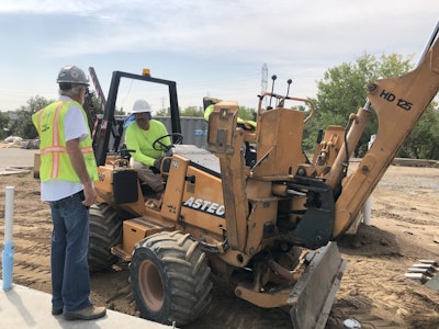 Eric Schultz, left, talks with one of his employees about the installation of some piping. Photo: Jill Odom