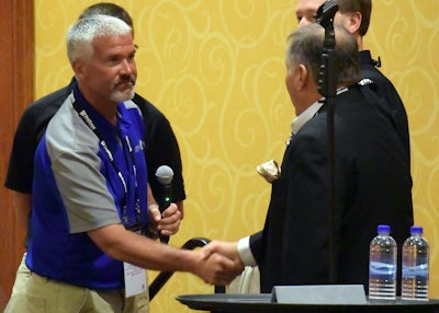 Lawn-Plus general manager Bob Brower (left) presents the check to Project EverGreen board member Fred Haskett. Photo: GreenCare for Troops