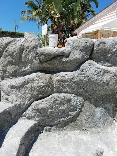 Rock Miller, Pool Crafters owner, uses Blastcrete’s D6528 concrete squeeze pump attachment to pump just five or six yards of concrete per hour, allowing more time to shape rock waterfalls. This image shows the rock prior to painting. Photo: Blastcrete