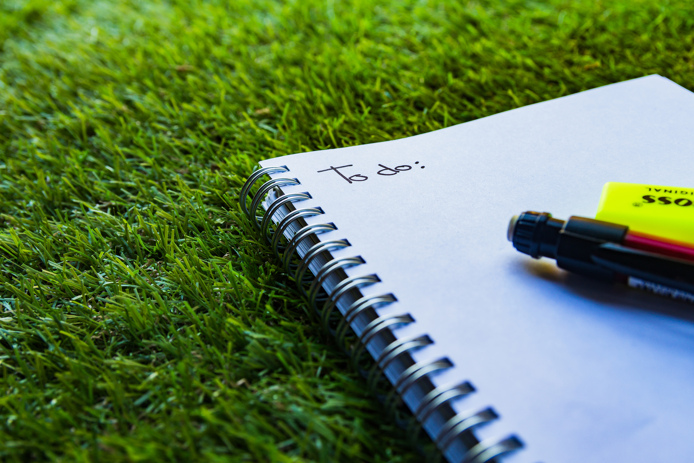 To-do list in a notebook laying in the grass