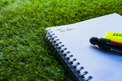 To-do list in a notebook laying in the grass