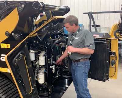 Buck Storlie, product line manager for ASV, shows how the rear engine compartment opens wide with three different doors to give you full and easy access to all the service points.