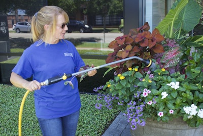 Sherri Thompson finishes off her work day by watering a few planters. Photo: Beth Hyatt/Total Landscape Care