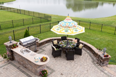 Outdoor kitchen and patio area overlooking pond