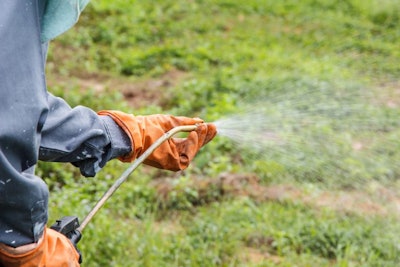 Landscaper adjusting the nozzle of a weed sprayer