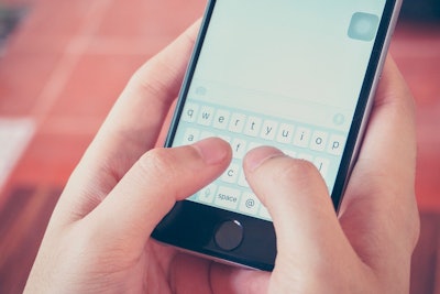 Hands holding a cell phone and ready to type a message