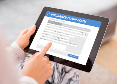 person holding a tablet with a digital insurance claim form to fill out