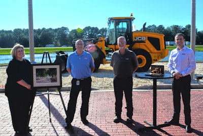 Neil Smith (second from left) pictured here with Tonya Poole, VP of HR; Spencer Howard, demonstration team manager; and Richard Fox-Marrs, JCB Inc. president and CEO. Photo: JCB