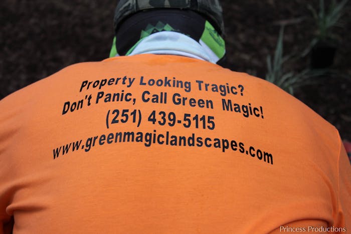 Landscaper wearing Green Magic Landscapes t-shirt