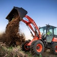 A Kubota R640 wheel loader dumping a bucket of dirt onto a pile