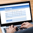 man taking an online survey on a laptop computer