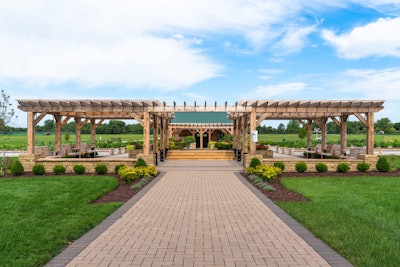 landscaped patio with sitting areas, walkways, and pergolas