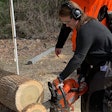 Beth Presley using a chainsaw to cut a log into slices