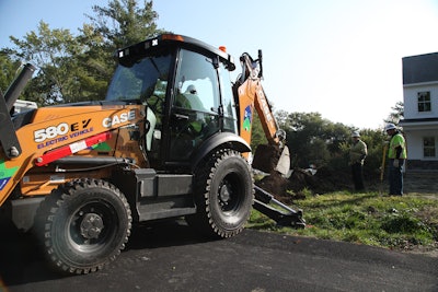 Case 580 electric backhoe loader being used to excavate dirt