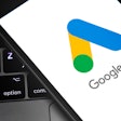 Google Ads logo on a smartphone that's sitting on top of a laptop keyboard