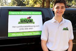 henry standing next to signage on a truck advertising his affordable lawn mowing services