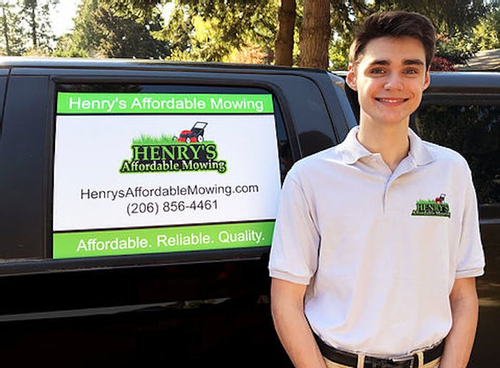henry standing next to signage on a truck advertising his affordable lawn mowing services
