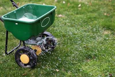 lawn spreader with wheels used to fertilize grass