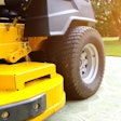 A yellow riding lawn mower parked on a driveway