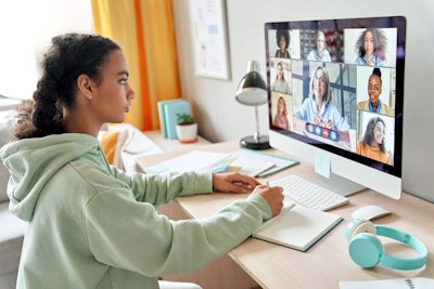 A student taking notes during a virtual meeting