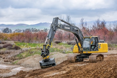 worker operating deere equipment on construction site