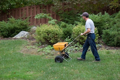 landscaping professional seeding a yard