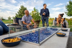 group of people sitting around an outdoor fire pit patio area