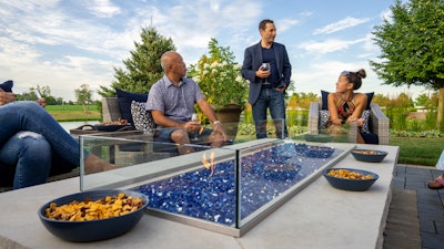 group of people sitting around an outdoor fire pit patio area