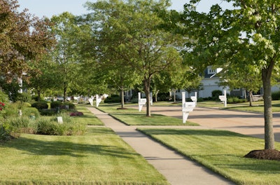 Community sidewalk lined with tress