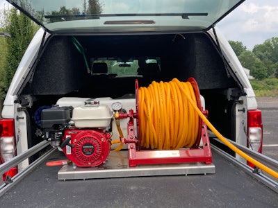 Pest control equipment hoses in the back of a landscaping truck