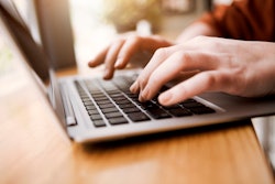 fingers typing on laptop