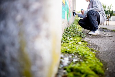 person spray painting a wall
