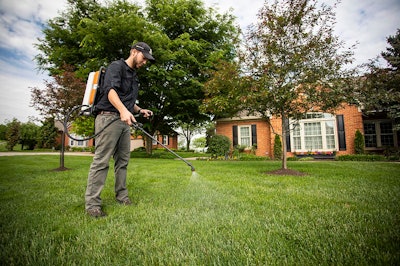 landscape technician spraying a lawn