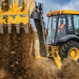 Deere 310 X-tier E-Power backhoe dumping dirt.