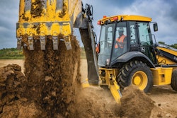 Deere 310 X-tier E-Power backhoe dumping dirt.