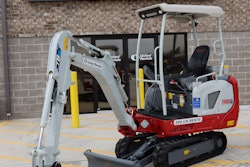 Takeuchi TB20e electric compact excavator parked in front of a United Rentals store.