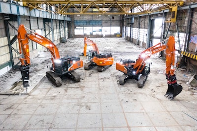Hitachi excavators in an empty warehouse construction site