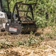Bobcat loader drum mulched clearing brush.