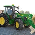 John Deere 5M Series tractor hauling a hay bale