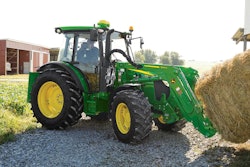 John Deere 5M Series tractor hauling a hay bale