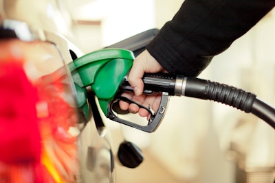 hand pumping gas into vehicle