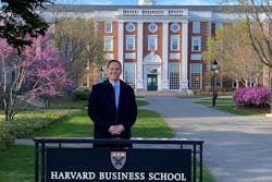 Josh Willey standing in front of a Harvard Business School sign