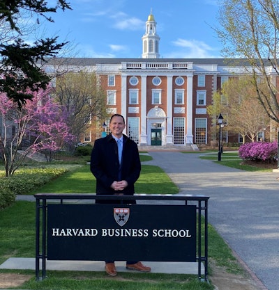 Josh Willey standing in front of a Harvard Business School sign