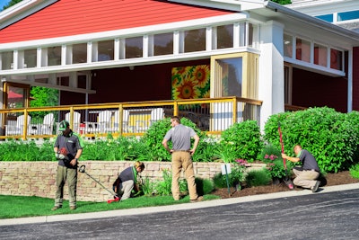 landscapers performing maintenance around property