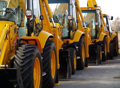 Backhoe loaders parked in a line