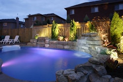 outdoor pool with lighting and landscape