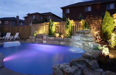 outdoor pool with lighting and landscape