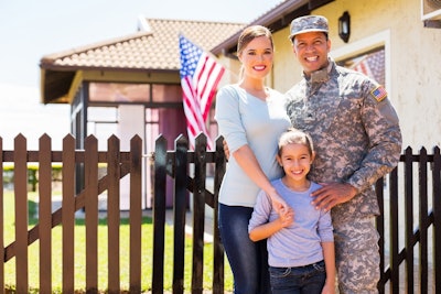 military family standing by a fence