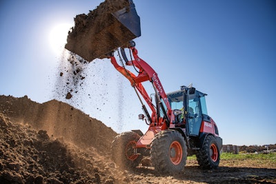 Kubota R640 compact wheel loader emptying dirt from bucket