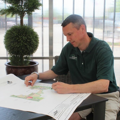 James Morris of English Gardens Landscape Company sitting at a table reviewing landscape blueprints